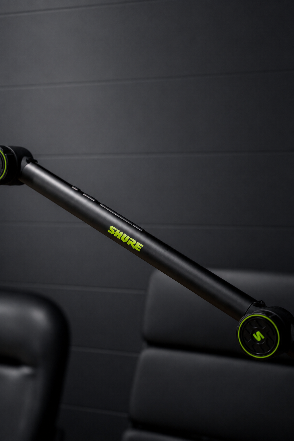 Detail of a Shure mic boom arm against a dark textured wall